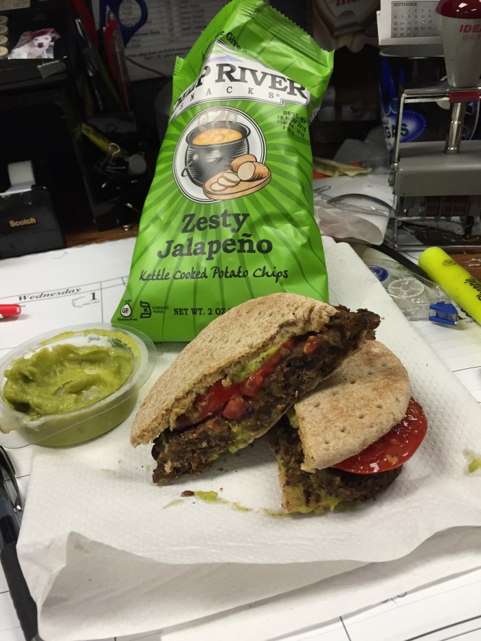 Spicy Zucchini and Black Bean burger with sliced tomato and guacamole.